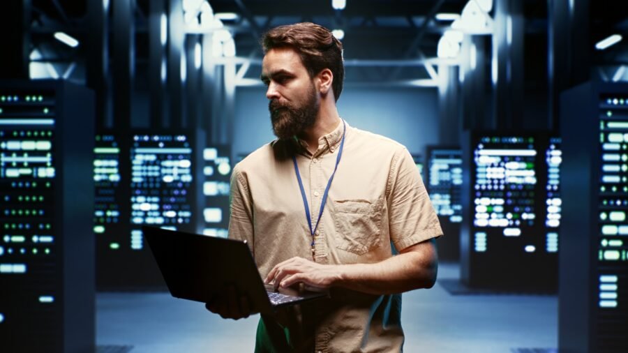 Caída Global de Amazon AWS: La Necesidad de una Infraestructura Independiente 1 Ingeniero que usa una computadora portátil para monitorear el consumo de energía en los componentes y distribuidores del servidor. Conceptual de la caída global de Amazon AWS