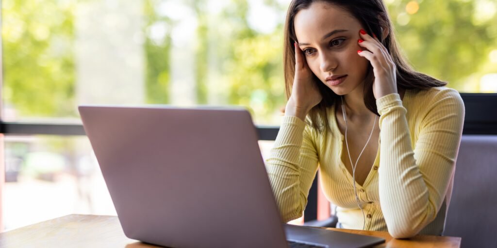 mujer joven cansada que trabaja en la computadora portatil en su espacio de trabajo 2